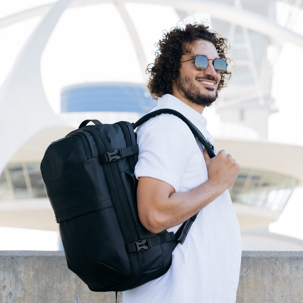 空港で、マットブラックの Backvac Pro を背負う男性