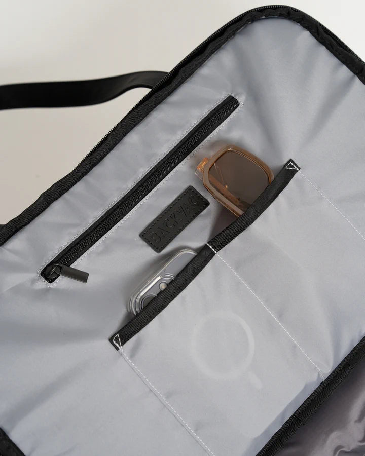Close do bolso com zíper e dos bolsos abertos na tampa, com um celular e óculos de sol